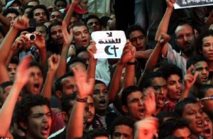 一位埃及抗议者在抗议中举着“不要宗派冲突”的标语牌