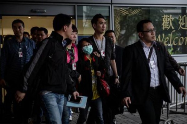 Erwiana is forced to leave the airport with police and Indonesian consular officials.
