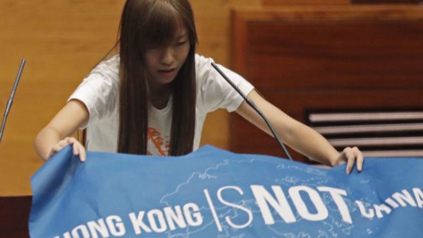 Yau Wai-ching of Youngspiration unfurls banner during oath-taking ceremony. 